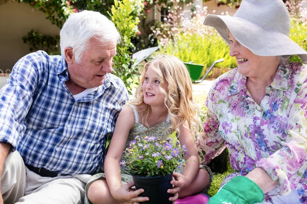 Far-och morföräldrar och barnbarn sitter i trädgården — Stockfoto