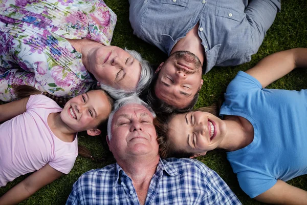 Familjen ligger tillsammans i trädgården — Stockfoto