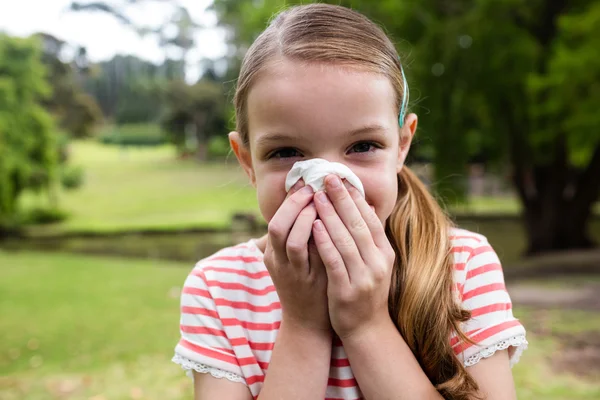 Chica enferma estornudando en el parque — Foto de Stock