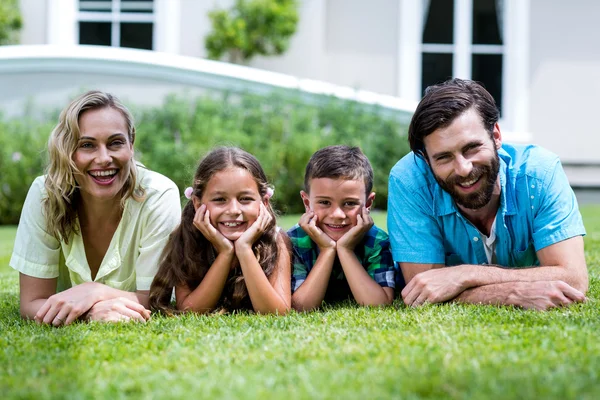 Famille couchée sur l'herbe à la cour — Photo