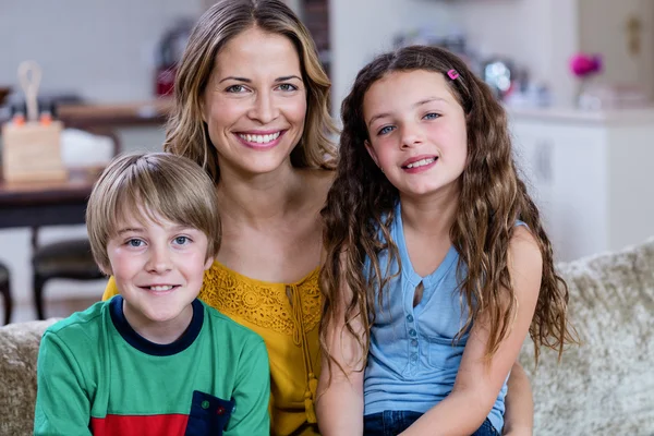 Mãe e filhos sentados em um sofá — Fotografia de Stock