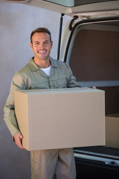 Homem de entrega carregando uma caixa de papelão — Fotografia de Stock