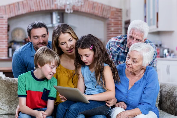 Familjen sitter på soffan och använder tablet — Stockfoto