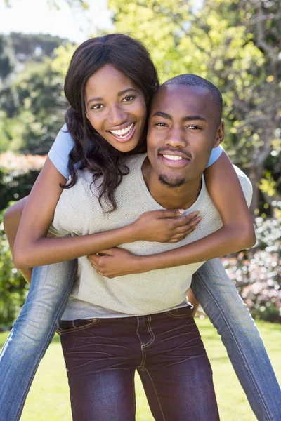 Man geven piggyback rit naar vrouw — Stockfoto