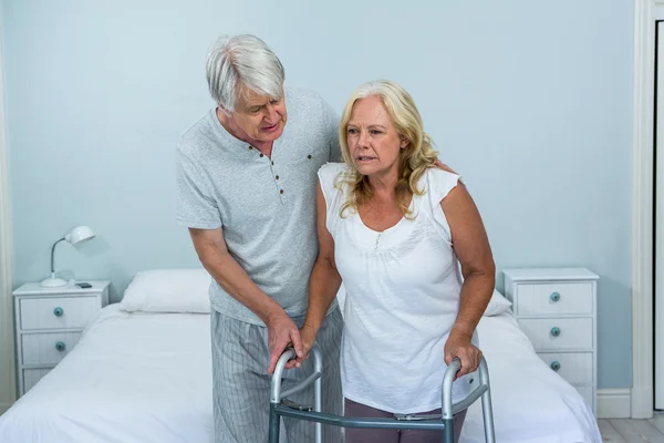 Uomo anziano aiutare la donna a camminare — Foto Stock