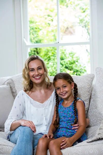 Madre e hija sentadas en un sofá — Foto de Stock