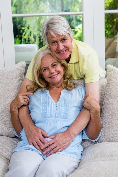 Äldre par embracing i vardagsrum — Stockfoto