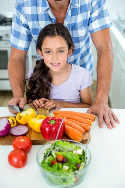 Daughter with father by vegetables at kitchen table — Stock Photo, Image