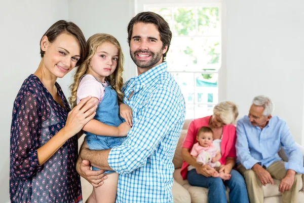 Rodina s úsměvem zatímco prarodiče v pozadí — Stock fotografie