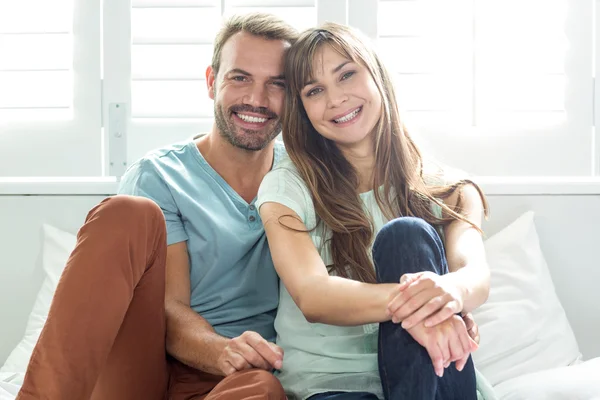 Couple relaxing on bed against window — Stock Photo, Image