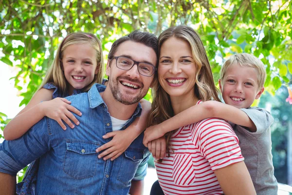 Parents giving piggy back to children — Stock Photo, Image