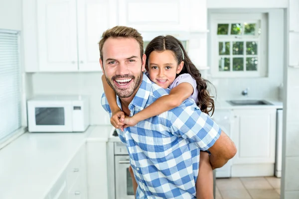 Vader boekwaarde dochter op rug — Stockfoto