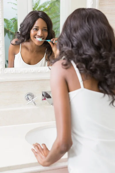 Mujer joven cepillándose los dientes — Foto de Stock