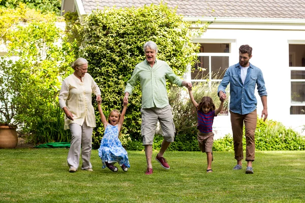 Family enjoying on grass at yard — Stock Photo, Image