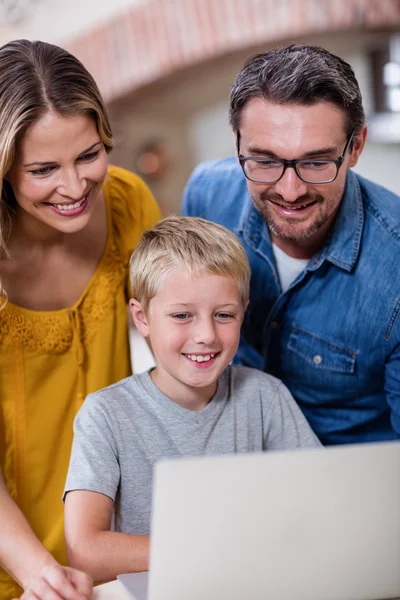 Pais e filho usando laptop na cozinha — Fotografia de Stock