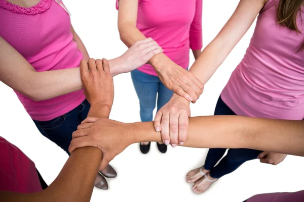 Women in pink outfits joining in circle — Stock Photo, Image