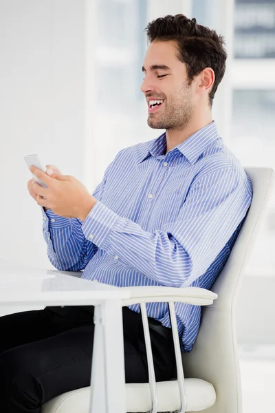 Mensajería de texto de hombre de negocios en el teléfono móvil — Foto de Stock