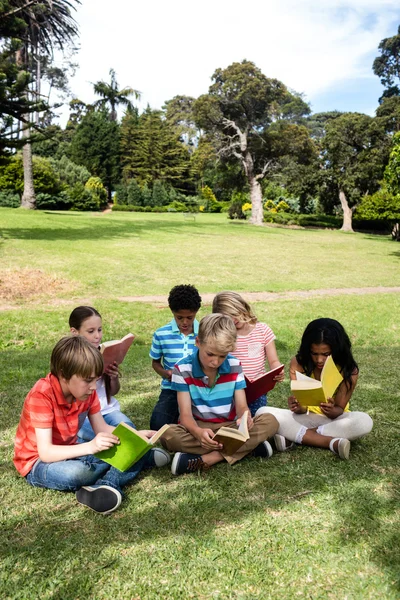 Enfants lisant un livre dans le parc — Photo