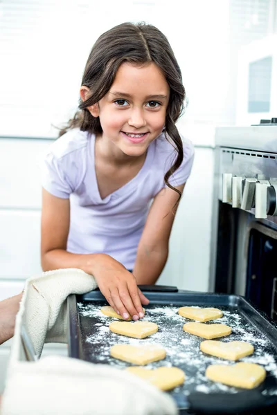 Flickan röra hjärtat formen cookies — Stockfoto