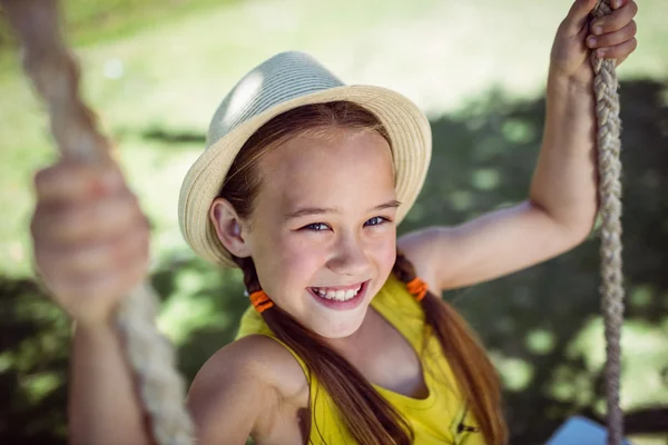 Meisje zit op schommel in park — Stockfoto