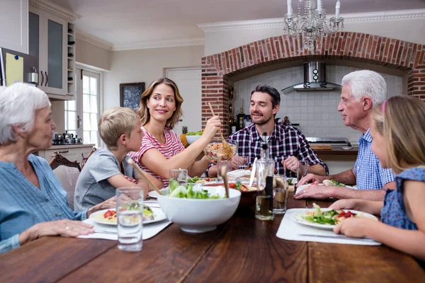 Donna che serve cibo alla famiglia in cucina — Foto Stock