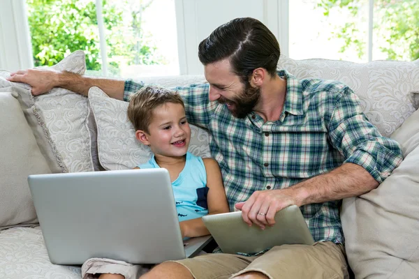 Pai sentado por filho com laptop — Fotografia de Stock