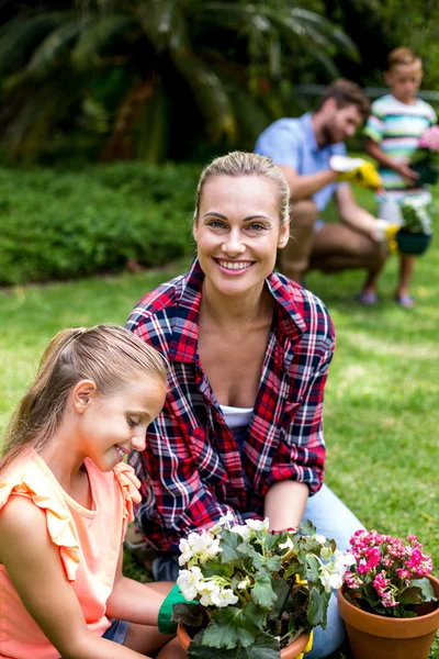 Madre aiutare figlia con vasi di fiori — Foto Stock