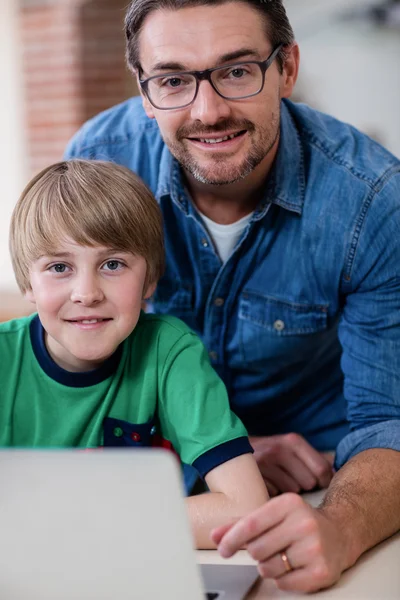 父亲和儿子在厨房中使用笔记本电脑 — 图库照片
