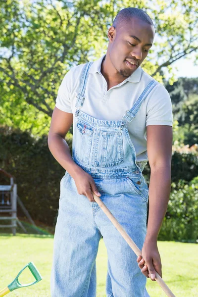 Homem no dungarees raking jardim — Fotografia de Stock