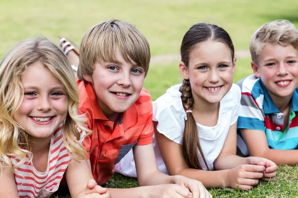 Niños felices tumbados en la hierba — Foto de Stock