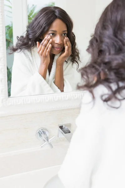 Femme vérifiant sa peau dans la salle de bain — Photo