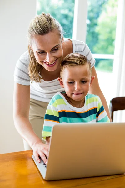 Mor och son använder laptop hemma — Stockfoto