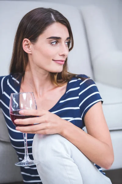 Žena sedí se sklenicí červeného vína — Stock fotografie