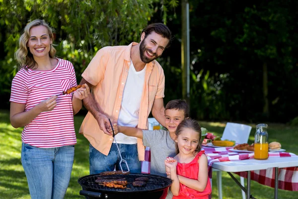 Familie koken voedsel op barbecue grill — Stockfoto