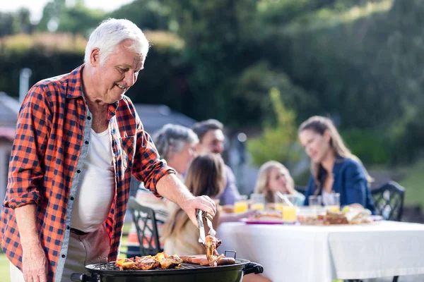 Senior man bij barbecue grill — Stockfoto