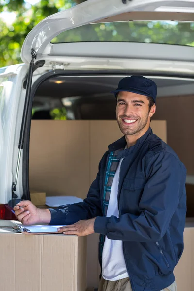 Delivery person writing in clipboard — Stock Photo, Image