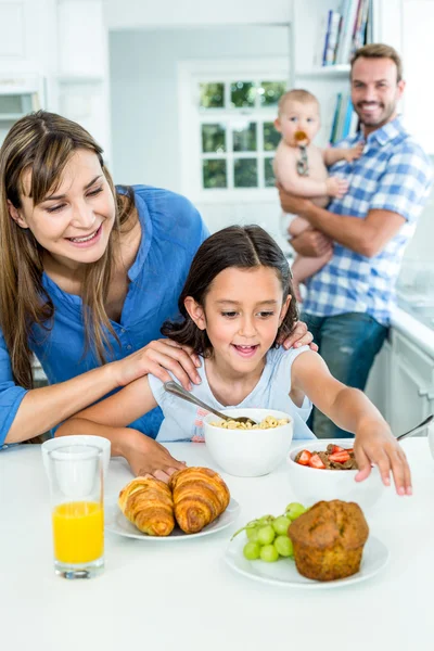 Woman looking at daughter having breakfast — Stock Photo, Image