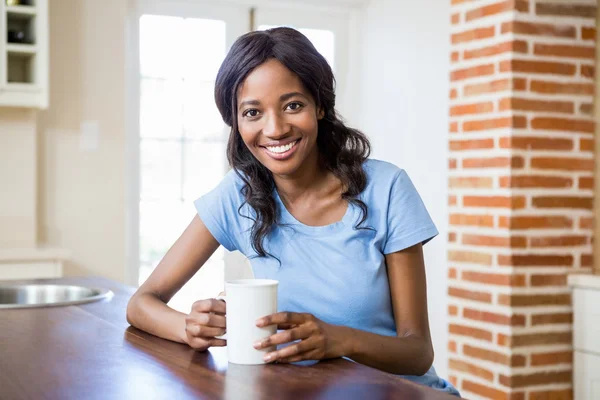 Жінка тримає чашку кави посміхаючись — стокове фото