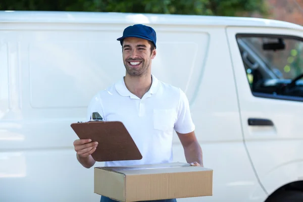 Homem de entrega com prancheta e caixa de papelão — Fotografia de Stock