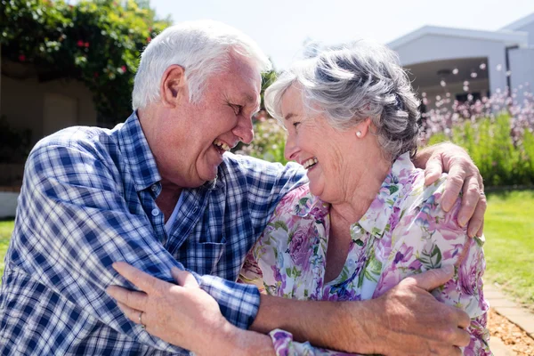Старшая пара обнимается в саду — стоковое фото