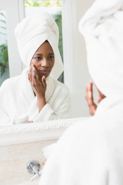 Mujer joven aplicando crema hidratante — Foto de Stock