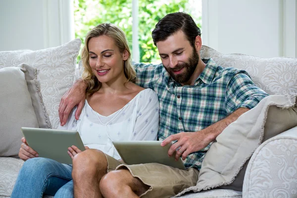 Casal usando tablet digital no sofá — Fotografia de Stock