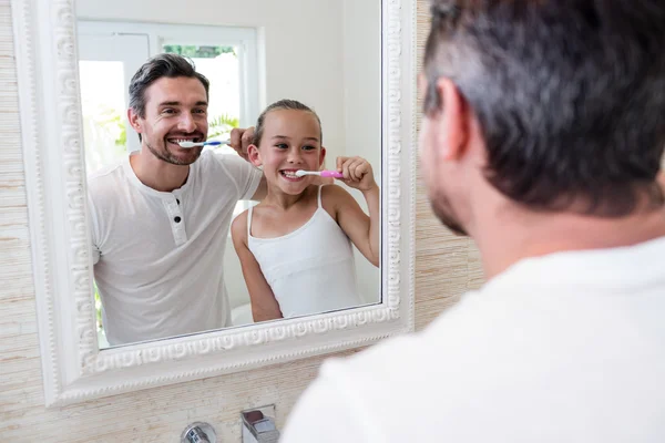 Vader en dochter tandenpoetsen in de badkamer — Stockfoto