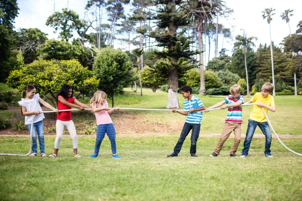 Kinderen trekken een touw in touwtrekken — Stockfoto