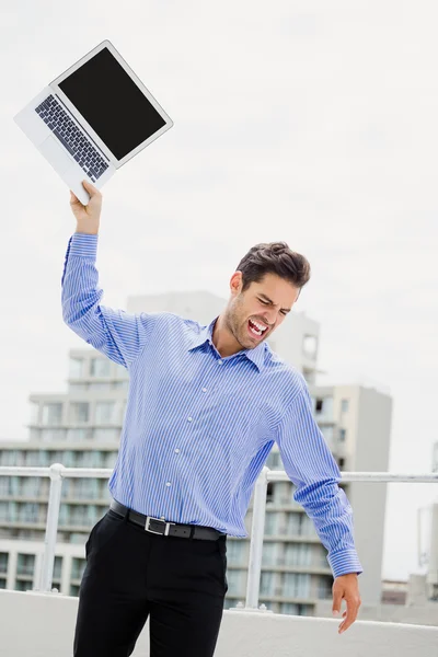 Uomo d'affari frustrato che lancia laptop — Foto Stock