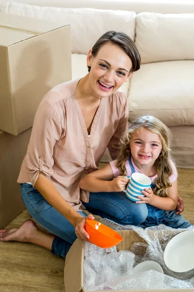 Mother and daughter unpacking box — Stock Photo, Image