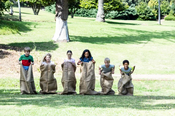 Дети участвуют в забеге на мешок в парке — стоковое фото