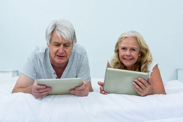 Couple utilisant des tablettes numériques dans la chambre — Photo