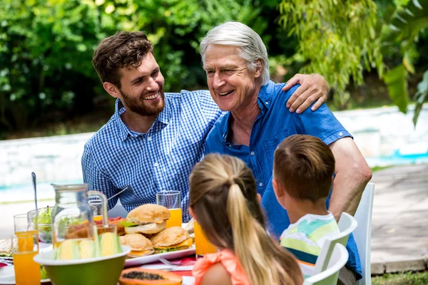 Vader en zoon met kinderen aan de eettafel — Stockfoto