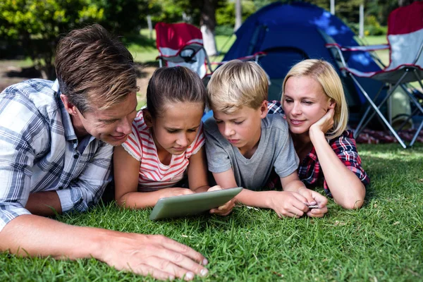 Aile çim üzerinde yalan ve tablet kullanma — Stok fotoğraf